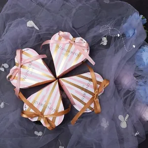 Close-up of heart-shaped gift boxes with pink stripes and decorative satin bows