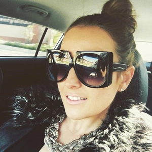 Detail view of black oversized square sunglasses with gradient lenses in everyday use