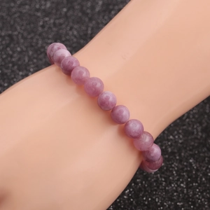 Close-up of a 10mm purple tiger eye gemstone bead bracelet on a model's wrist