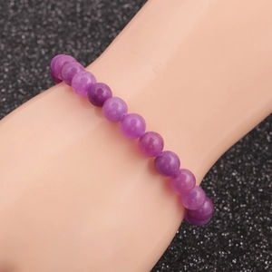 Close-up of a purple tiger eye bead bracelet featuring smooth round natural gemstones
