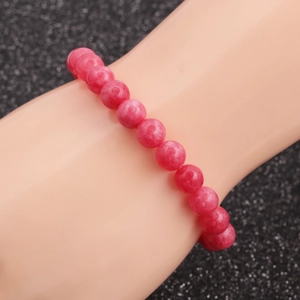 Detail showing pink agate beaded bracelet with natural texture on a model wrist