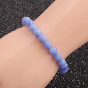 Minimalist agate beaded bracelet with blue and purple stones on a textured black backdrop