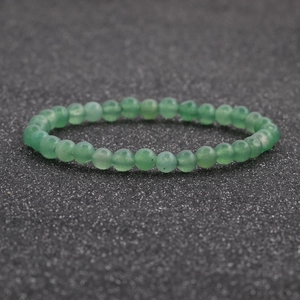 Primer plano detallado de una pulsera de cuentas de ágata verde de 6 mm sobre fondo oscuro