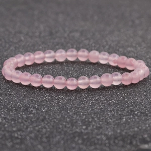 Detalle macro de la pulsera de cuentas de cuarzo rosa con textura rosa translúcida