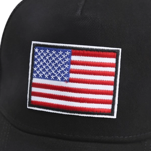Macro detail of high-quality US flag embroidery on a black cotton baseball cap
