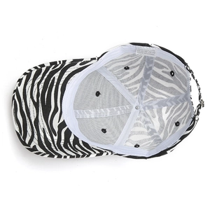 Détail d'une casquette zébrée en coton montrant l'étiquette 100% coton et la boucle en métal