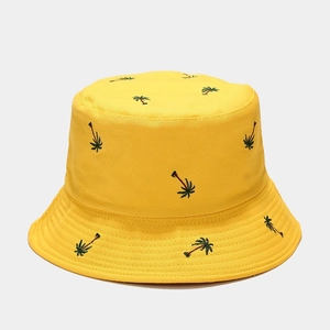 Close-up of coconut tree embroidery detail on vibrant yellow cotton bucket hat