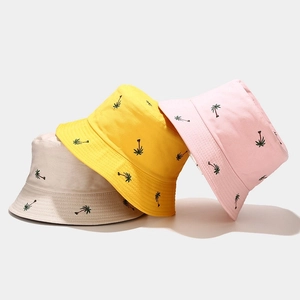 Three embroidered coconut tree bucket hats in beige, yellow, and pink colors for sun protection