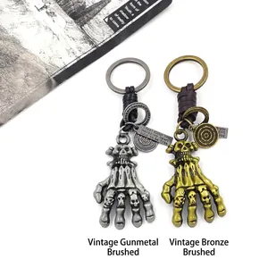 Skull Hand Schlüsselanhänger in Antik-Gunmetal und Bronze mit Punk-Lederverzierung