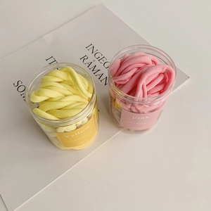 Macro detail of seamless elastic hair ties in yellow and pink Girl's Rainbow containers