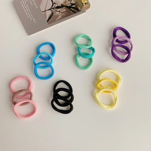 Close-up of 18 rainbow gradient seamless velvet hair ties neatly arranged on white background