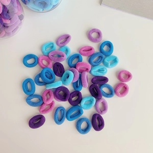 Macro shot of colorful gradient seamless elastic hair ties scattered on white background
