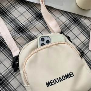 Detail of cream canvas crossbody bag showing woven texture and MEIXIAOMEI lettering