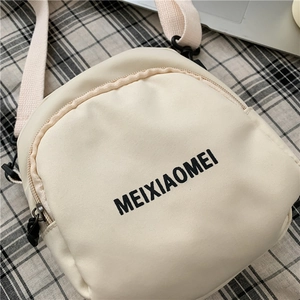 Detailed top view of a cream-colored nylon crossbody bag with black text on checkered fabric