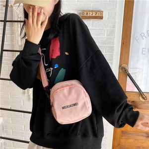 Detail shot of the pink crossbody bag featuring black letter print and adjustable strap