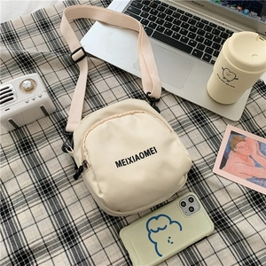Top view of cream-colored canvas crossbody bag with MEIXIAOMEI text on checkered cloth