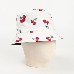 Détail de l'imprimé cerises sur le bob en coton blanc avec bordure de couture renforcée
