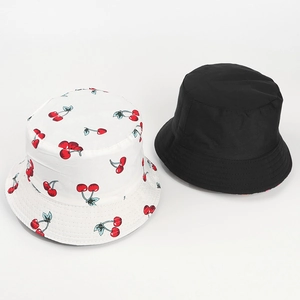 Détail de bobs en coton réversibles avec imprimé cerise rouge et design noir classique