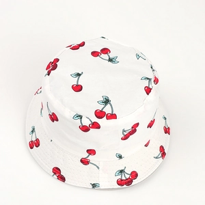 Gros plan d'un chapeau bob en coton blanc avec motifs cerises rouges et surpiqûres