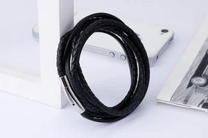 Detail of multi-layer woven black leather bracelet with silver cylindrical clasp