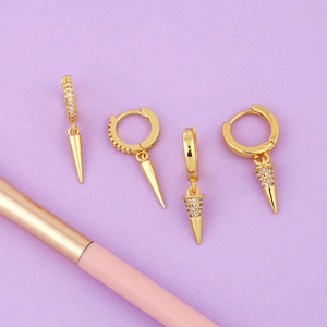 Detail of four-piece gold huggie earrings with spiked cone charms and pavé zircon stones