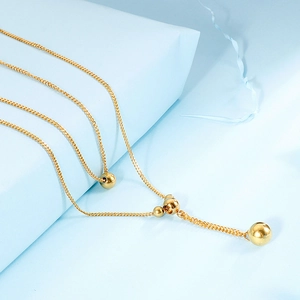Collier double couche en acier titane doré avec perles géométriques et chaîne serpent