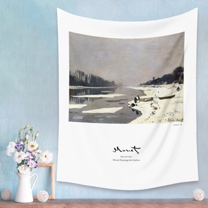 Detail of Monet landscape art tapestry hanging on a blue wall with home decor accessories