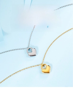 Detailed view of heart-shaped lock pendants in gold and silver on a blue background