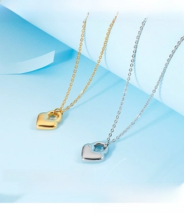 Detailed close-up of gold and silver heart pendants on delicate fine cross chains