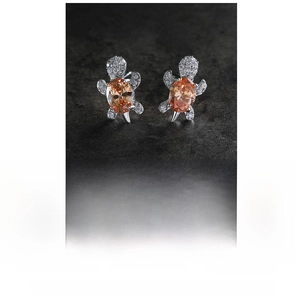 Detail view of turtle earrings with orange cubic zirconia in 14K white gold plating