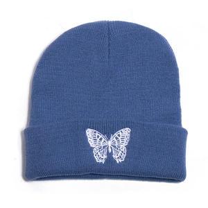 Detail of blue knitted beanie with white butterfly embroidery and premium rib texture