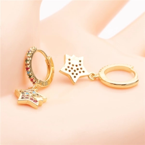 Macro detail of gold star earrings with colorful cubic zirconia on a realistic hand model