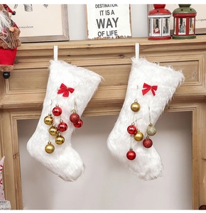 Detail of white plush Christmas stockings with red bows and festive gold ornaments