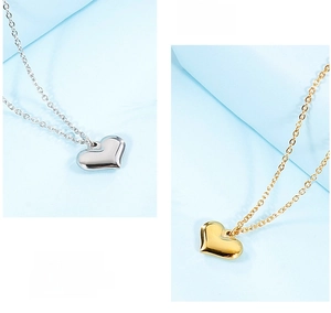 Close-up of polished gold and silver heart pendants on delicate cross chains