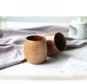 Macro detail of two charred wooden tea cups with natural wood grain on a zen tabletop
