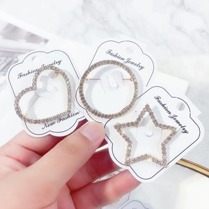 Set of gold alloy geometric heart and star brooches with inlaid rhinestones on white card