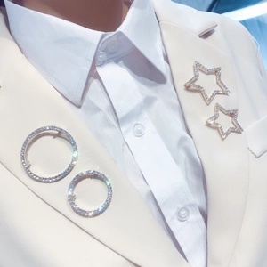 Detailed view of alloy brooches with sparkling rhinestones in star and ring shapes