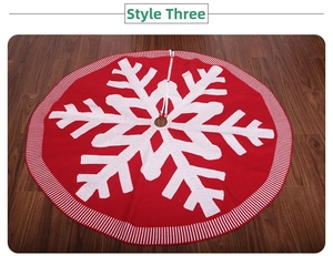 Close-up of red knitted Christmas tree skirt with white snowflake and striped border