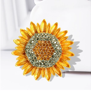 Macro detail of sunflower brooch with golden petals and sparkling crystal center
