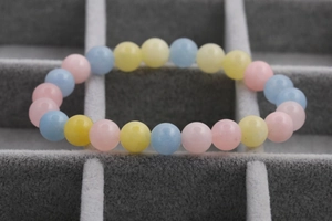 Macro shot of macaron-colored pink yellow and blue beaded bracelets in a velvet box
