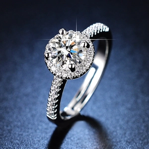 Elegant six-prong silver ring with a round brilliant cut moissanite on blue background