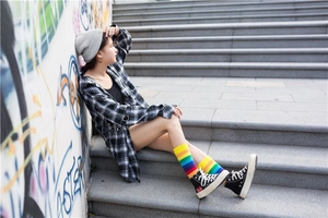 Street style shot of colorful rainbow striped high socks paired with casual sneakers