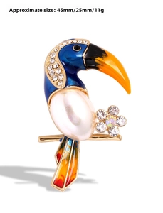 Detailed view of colorful toucan brooch with faux pearl and rhinestone accents