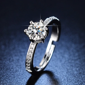 Macro shot of silver moissanite ring showing the six-prong setting and cross starlight effect