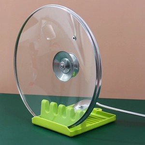 Multifunctional green kitchen utensil rest for pot lid and spatula storage on countertop