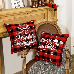 Red buffalo plaid Christmas pillow covers with reindeer print on a rustic wooden chair