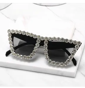 Close-up of luxury oversized black sunglasses with sparkling rhinestones on marble