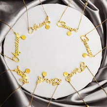 Close-up of golden script zodiac necklaces including Aquarius and Leo on stone display