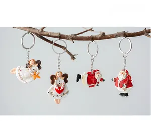 Christmas angel and Santa keychains hanging on natural wood branches for festive decor