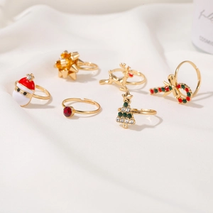 Detail of 6-piece Christmas ring set featuring reindeer and trees on white fabric